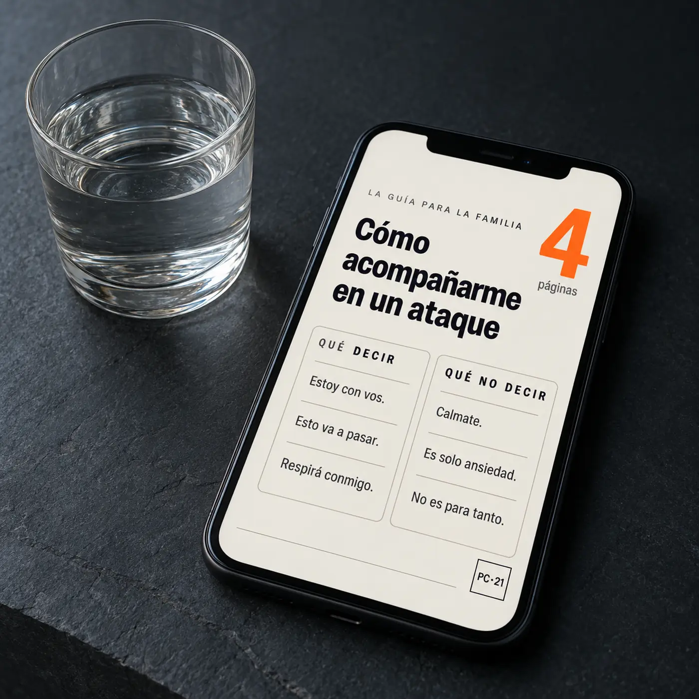 La Guía para la Familia abierta en un celular, al lado de un vaso de agua